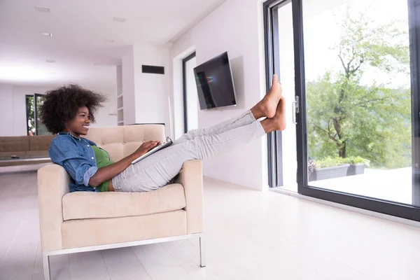 Mulheres afro-americanas em casa na cadeira usando um laptop — Fotografia de Stock