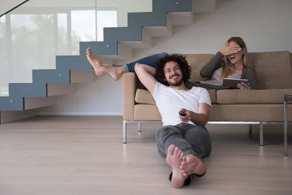 Ungt par slappnar av i vardagsrummet — Stockfoto