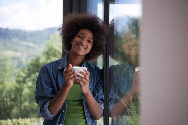喝咖啡看着窗外的非洲裔美国老妇 — 图库照片