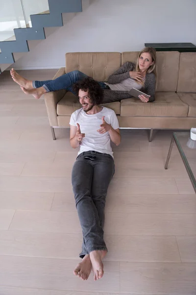 Mladý pár se uvolňuje v obývacím pokoji — Stock fotografie