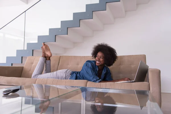 Donna afroamericana che utilizza il computer portatile sul divano — Foto Stock