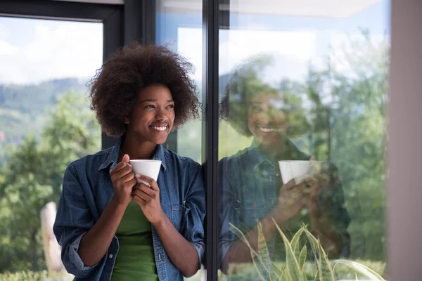 Afrikai-amerikai nő, ivás, kávé kinézett az ablakon — Stock Fotó