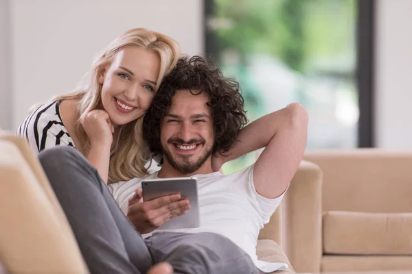 Pár v pohodlí domova u počítačů typu tablet — Stock fotografie