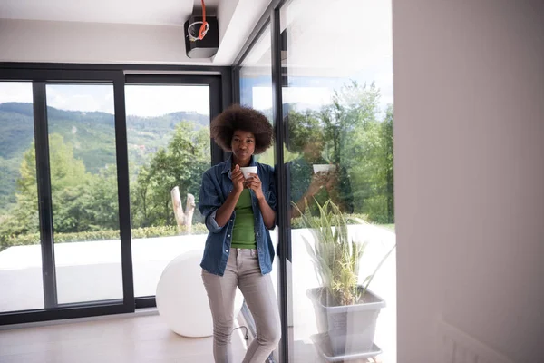 Afroamerikanerin trinkt Kaffee und schaut aus dem Fenster — Stockfoto