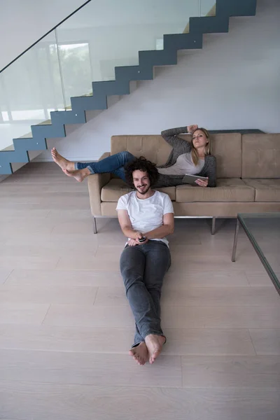 Ungt par slappnar av i vardagsrummet — Stockfoto