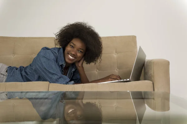 Mujer afroamericana usando portátil en sofá —  Fotos de Stock