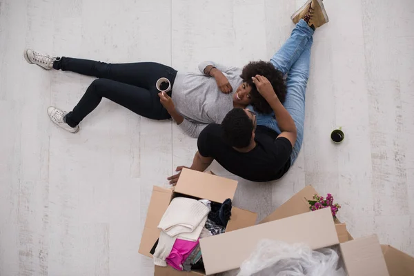 Casal afro-americano relaxante em nova casa — Fotografia de Stock