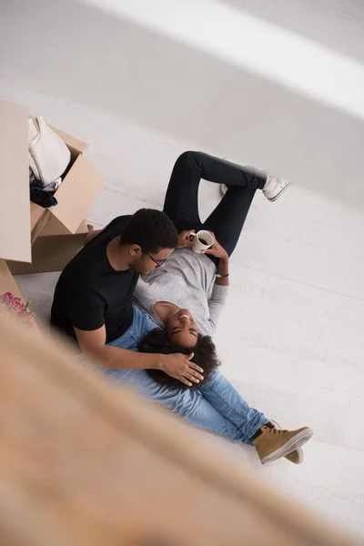 Casal afro-americano relaxante em nova casa — Fotografia de Stock