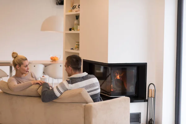 Pareja joven frente a la chimenea —  Fotos de Stock