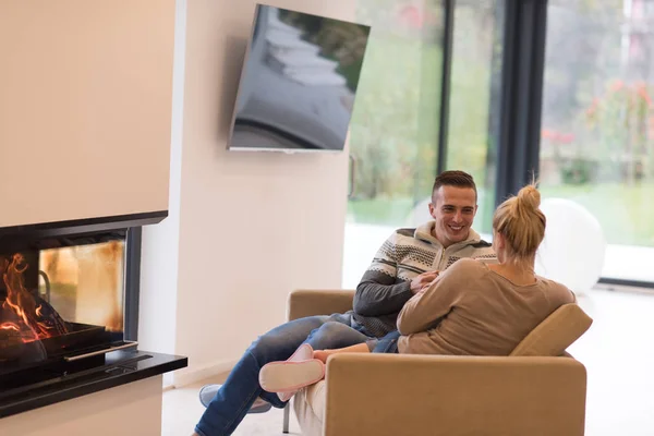 Pareja joven frente a la chimenea — Foto de Stock