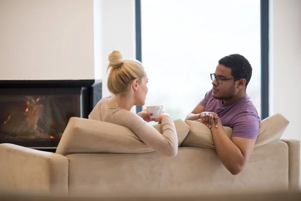 Pareja joven multiétnica frente a la chimenea —  Fotos de Stock