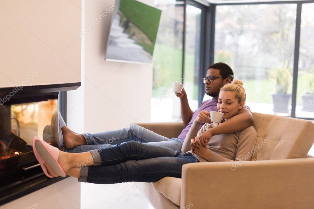 Young multiethnic couple  in front of fireplace