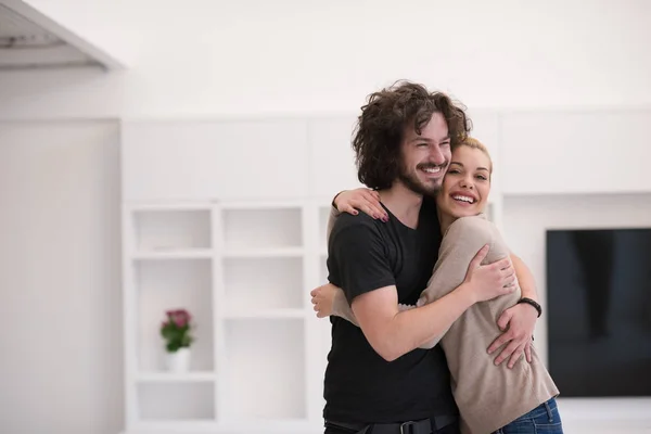 Paar knuffelen in hun nieuwe huis — Stockfoto