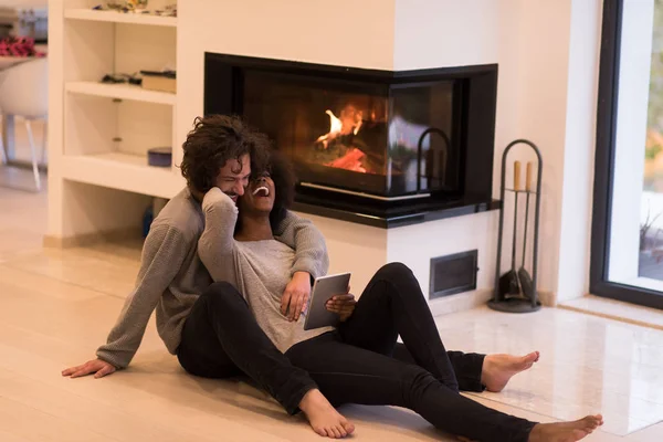 Mnohonárodnostní pár použít tabletový počítač na podlaze — Stock fotografie