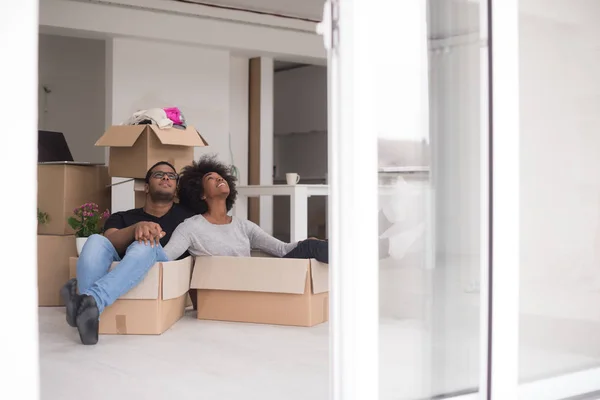 Pareja afroamericana jugando con material de embalaje — Foto de Stock