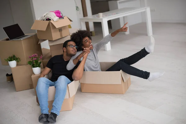 Pareja afroamericana jugando con material de embalaje — Foto de Stock