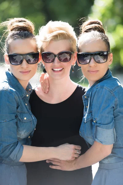 Retrato de tres mujeres jóvenes y hermosas con gafas de sol — Foto de Stock