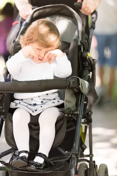 Meisje van de baby in de kinderwagen zitten — Stockfoto