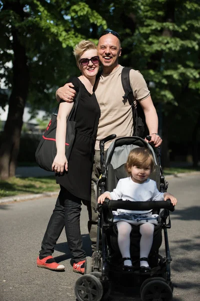 Couple with baby pram in summer park — Stock Photo, Image