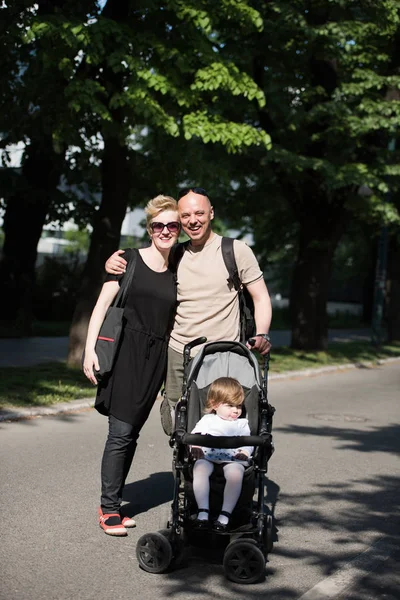 Casal com carrinho de bebê no parque de verão — Fotografia de Stock
