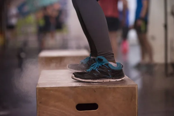 Nero donna sta eseguendo box salti a palestra — Foto Stock