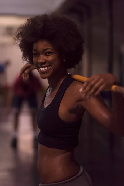 Mujer negra levantando barra vacía — Foto de Stock