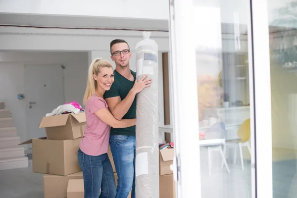 Couple carrying carpet into new home — Stock Photo, Image