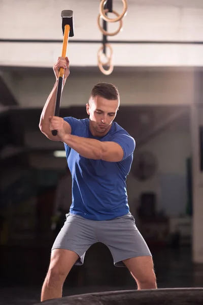 Training van de man met de hamer en trekker banden — Stockfoto