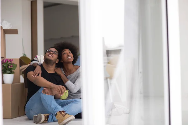 Casal afro-americano relaxante em nova casa — Fotografia de Stock