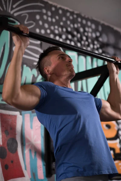 Homem fazendo pull ups — Fotografia de Stock