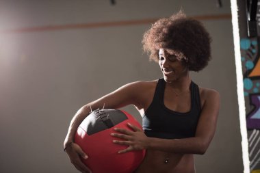 black woman carrying crossfit ball clipart