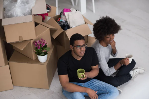 Casal afro-americano relaxante em nova casa — Fotografia de Stock