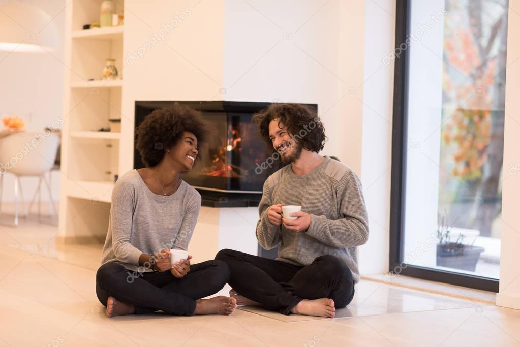 multiethnic couple  in front of fireplace