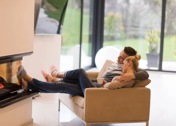 Молодая романтическая пара, сидящая на диване — стоковое фото