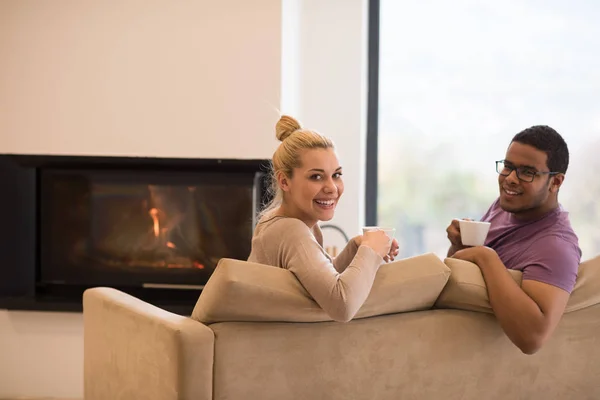 Pareja joven multiétnica frente a la chimenea —  Fotos de Stock