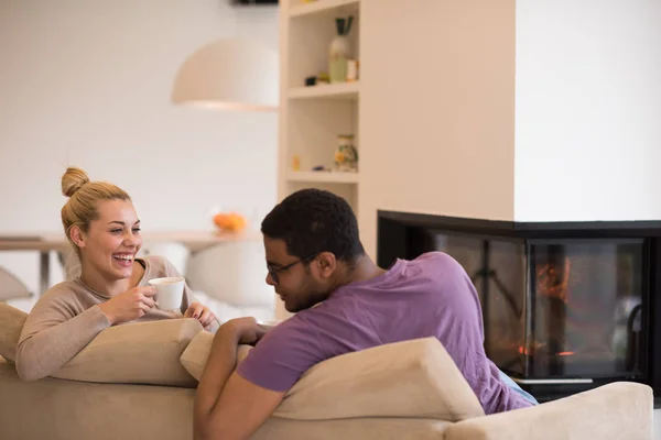 Pareja joven multiétnica frente a la chimenea —  Fotos de Stock