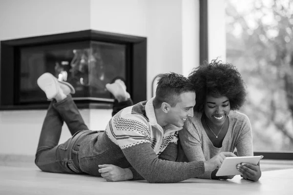 Multietniskt par använde tablet PC på golvet — Stockfoto
