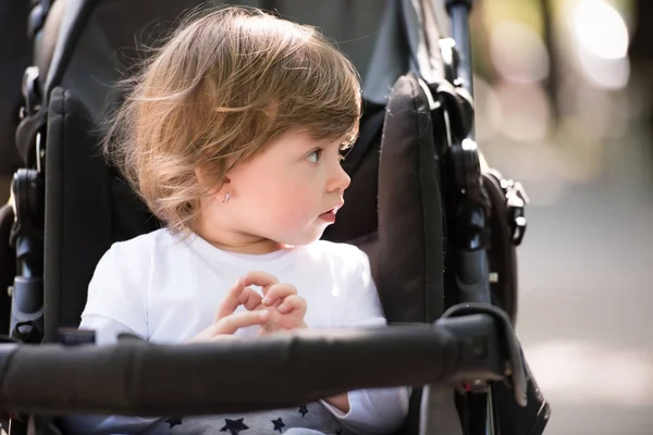 Baby flicka sitter i barnvagnen — Stockfoto