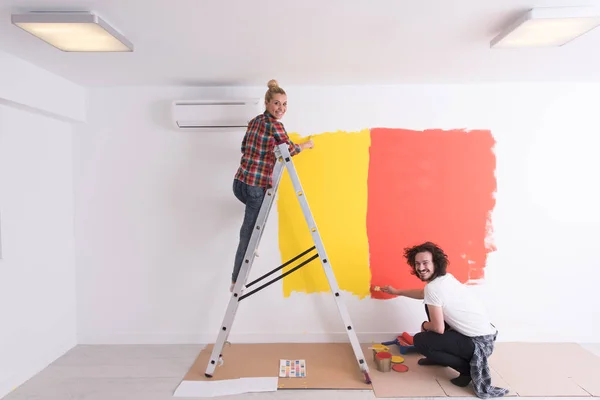 Пара малює внутрішню стіну — стокове фото