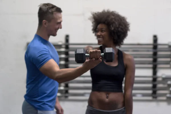 Black woman doing bicep curls with fitness trainer — Stock Photo, Image