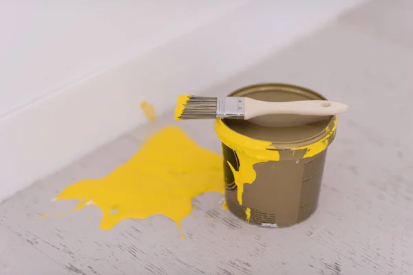 Boîte de peinture jaune avec pinceau sur le dessus — Photo