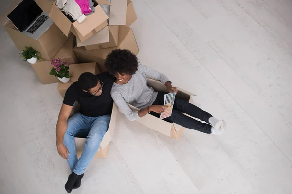 Pareja afroamericana jugando con material de embalaje — Foto de Stock