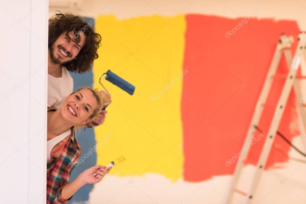 couple painting interior wall