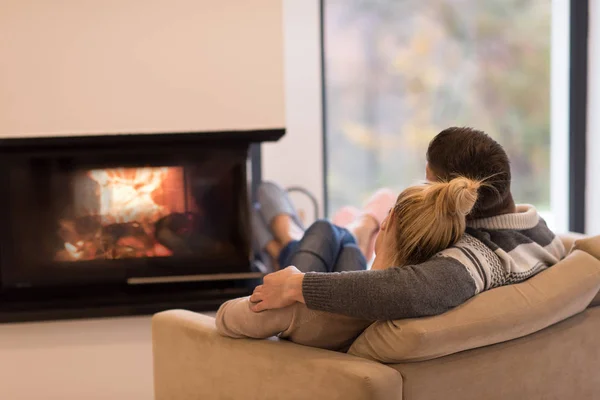 Pareja joven frente a la chimenea —  Fotos de Stock