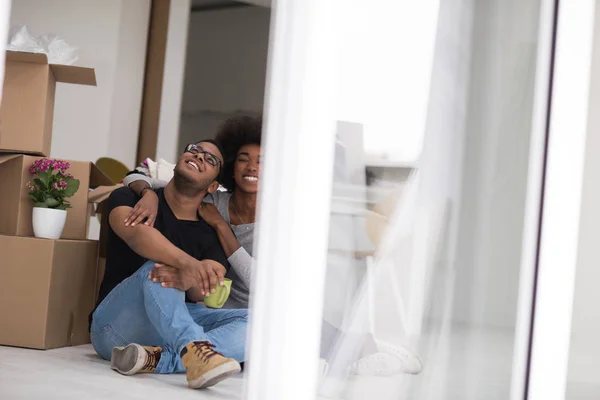 Pareja afroamericana relajándose en casa nueva — Foto de Stock