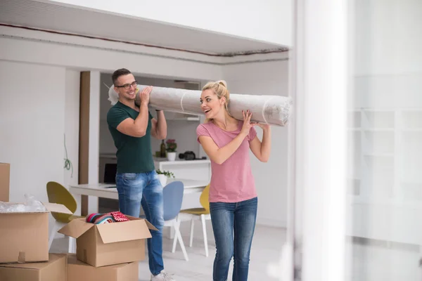 Casal transportando tapete para casa nova — Fotografia de Stock