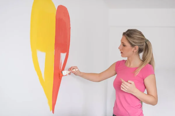 Femme peignant un coeur sur le mur — Photo