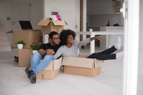 Pareja afroamericana jugando con material de embalaje — Foto de Stock