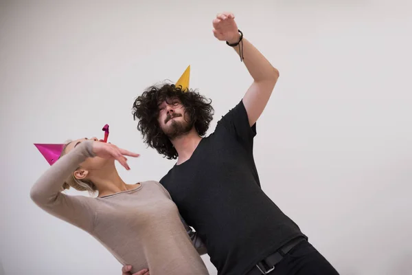 Casal em chapéus de festa soprando no apito — Fotografia de Stock