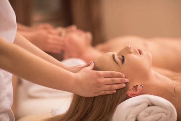 Casal desfrutando de massagem na cabeça no spa — Fotografia de Stock